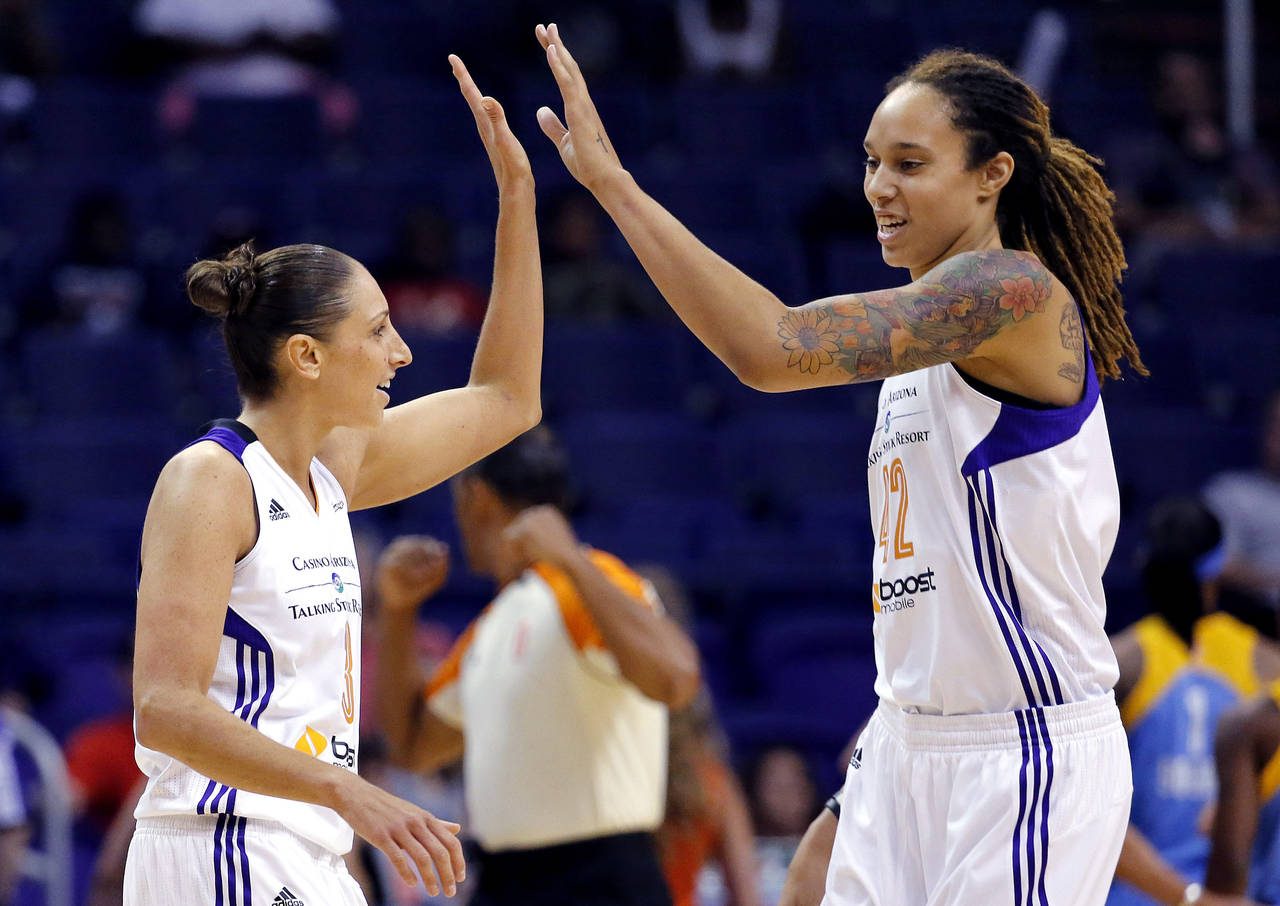 FILE - Phoenix Mercury guard Diana Taurasi, left, high-fives teammate Brittney Griner during the fi...