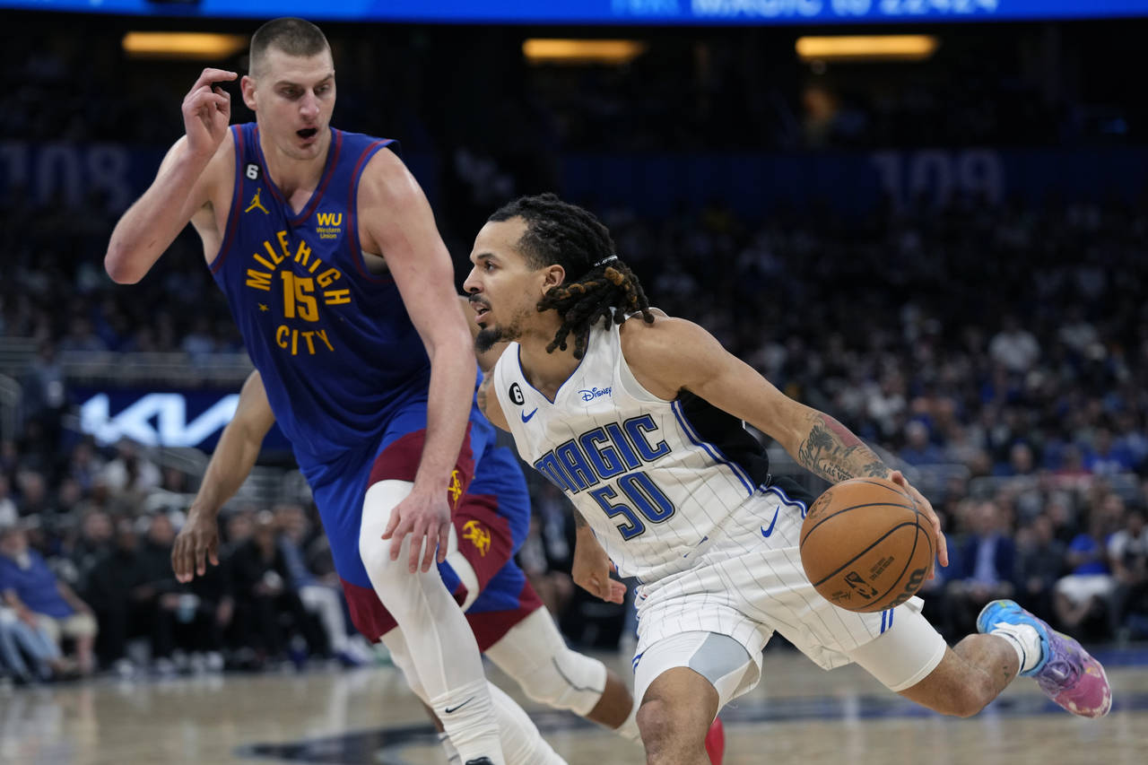 Orlando Magic guard Cole Anthony (50) drives around Denver Nuggets center Nikola Jokic (15) during ...