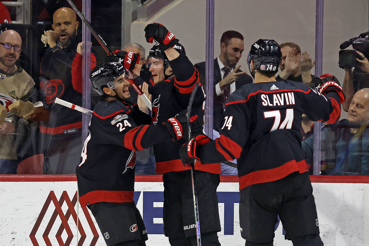 Carolina Hurricanes' Andrei Svechnikov, center, celebrates his goal with teammates Seth Jarvis (24)...