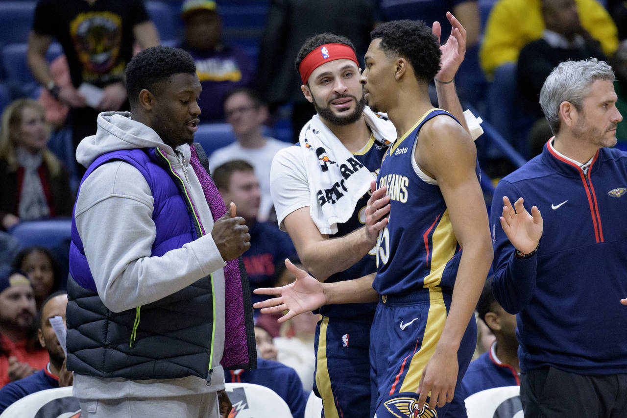 New Orleans Pelicans forward Zion Williamson, left, and forward Larry Nance Jr., center, congratula...