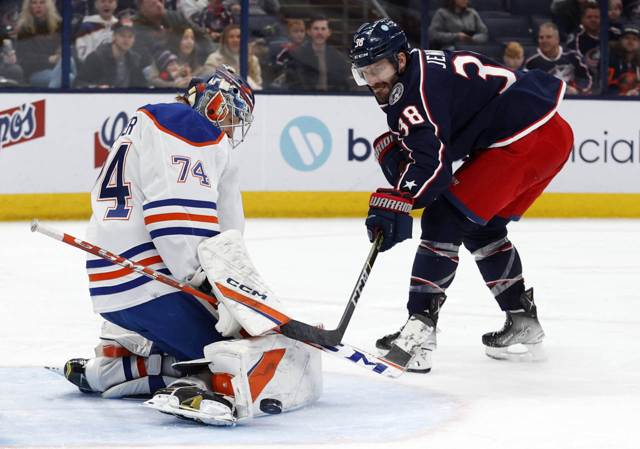Edmonton Oilers goalie Stuart Skinner, left, stops a shot by Columbus Blue Jackets forward Boone Je...