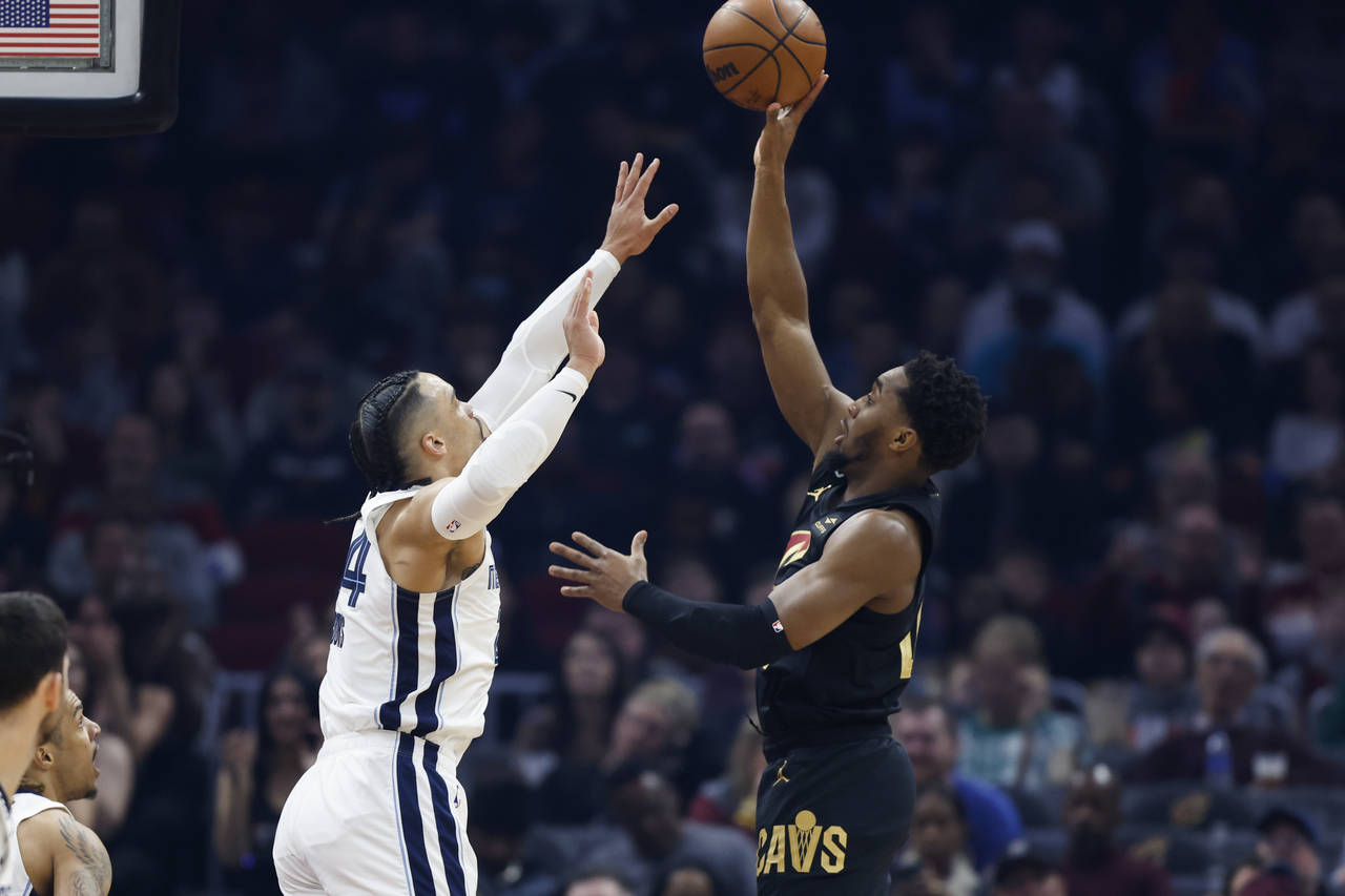 Cleveland Cavaliers guard Donovan Mitchell, right, shoots against Memphis Grizzlies forward Dillon ...