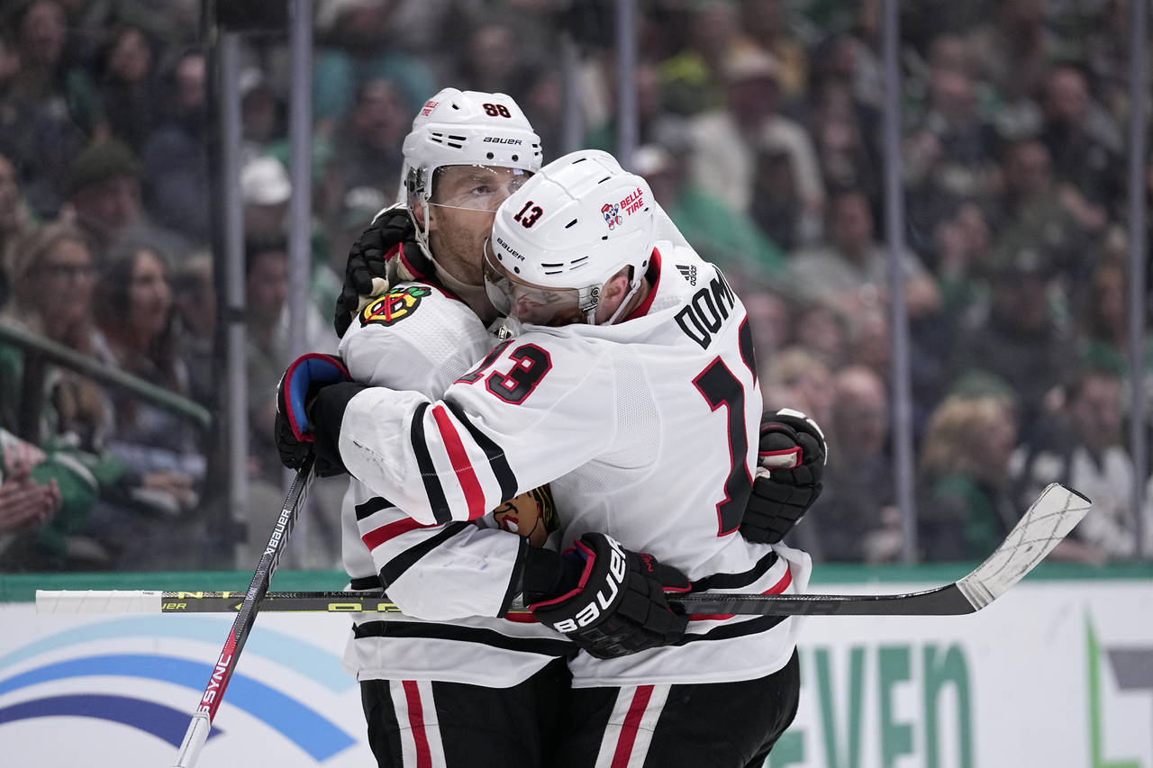 Chicago Blackhawks' Patrick Kane (88) and Max Domi (13) celebrate after Domi scored off an assist f...
