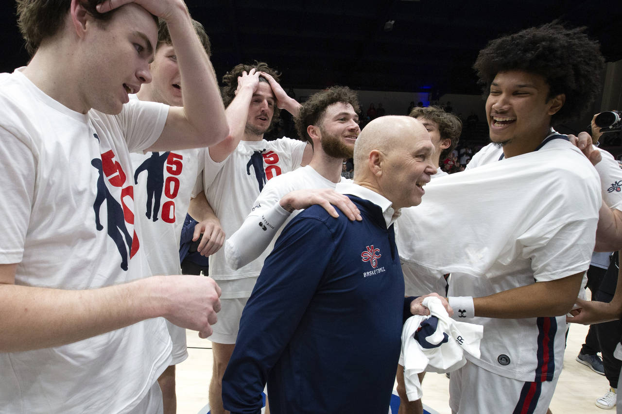 Saint Mary's head coach Randy Bennett, center, is congratulated by his players after notching his 5...