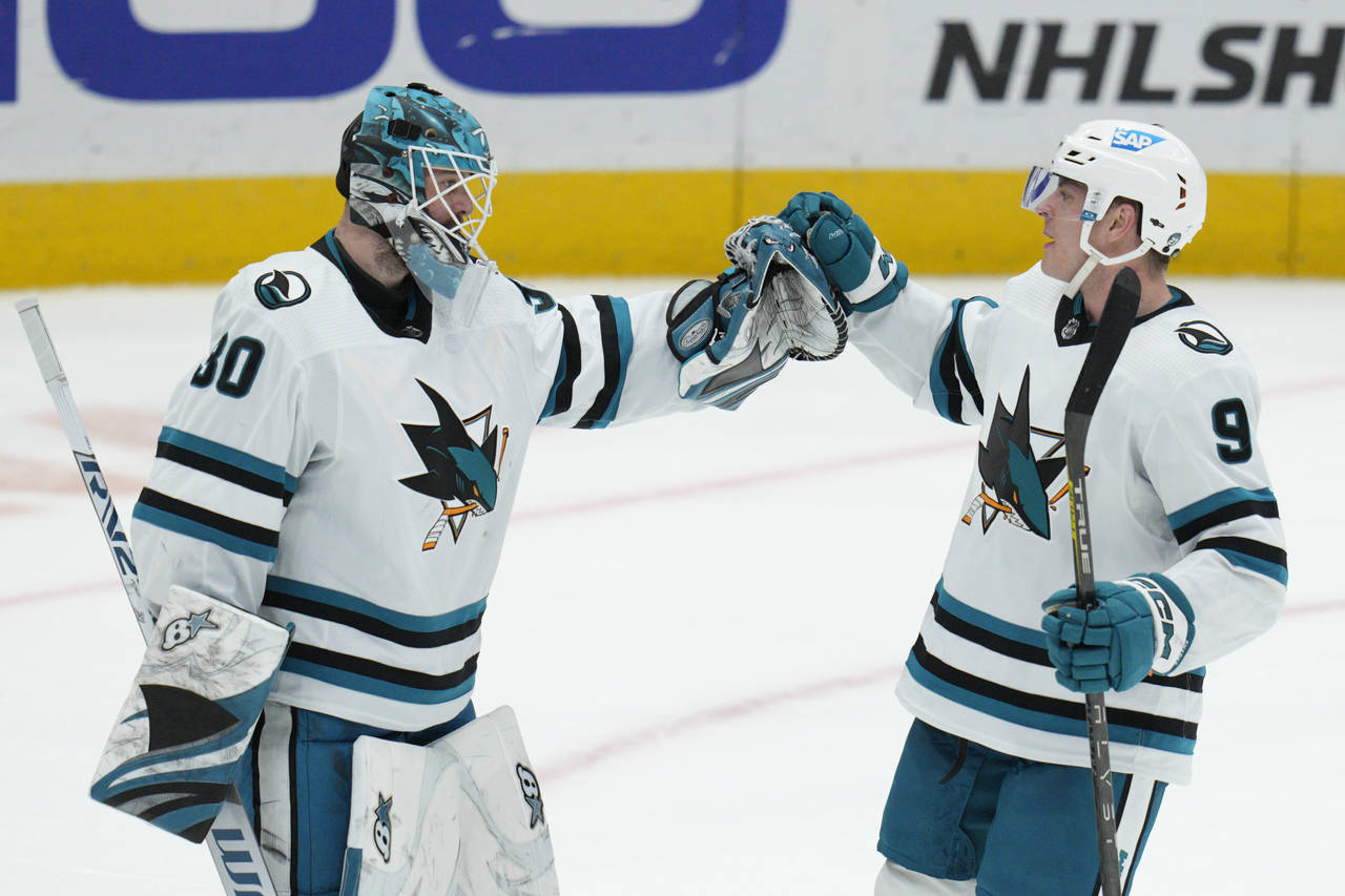 San Jose Sharks goaltender Aaron Dell (30) celebrates with defenseman Jacob MacDonald (9) after an ...