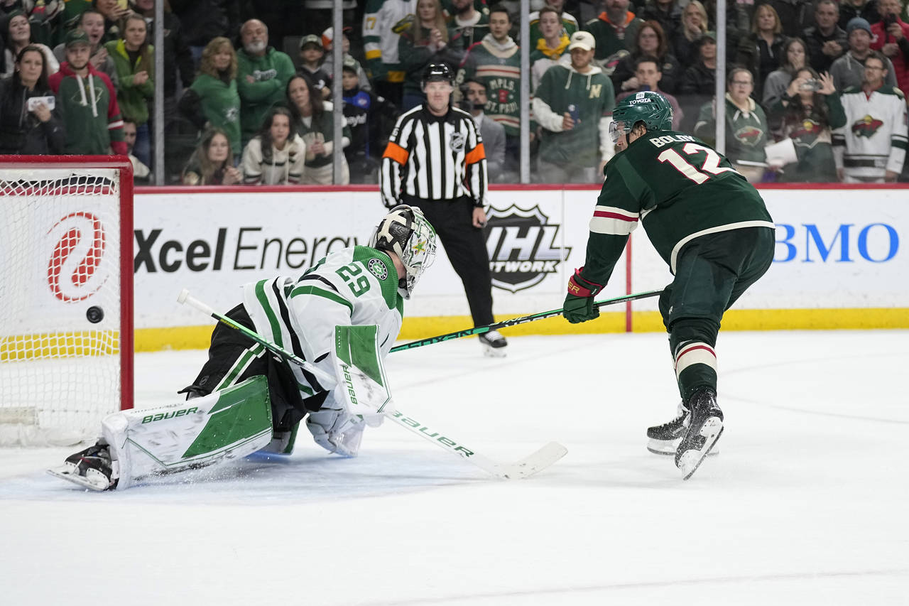 Minnesota Wild left wing Matt Boldy (12), right, shoots and scores a goal past Dallas Stars goalten...