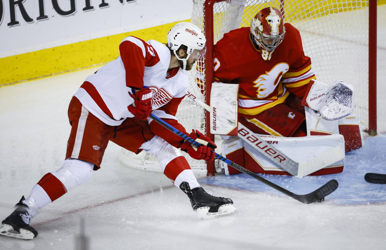 Detroit Red Wings forward Michael Rasmussen, left, tries to score against Calgary Flames goalie Dan...