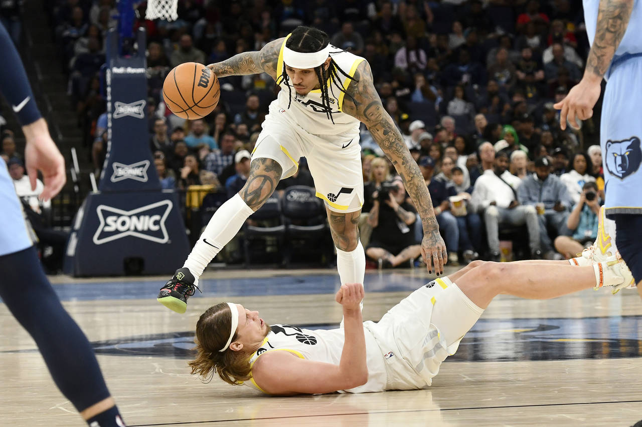 Utah Jazz guard Jordan Clarkson (00) stumbles over forward Kelly Olynyk during the first half of th...