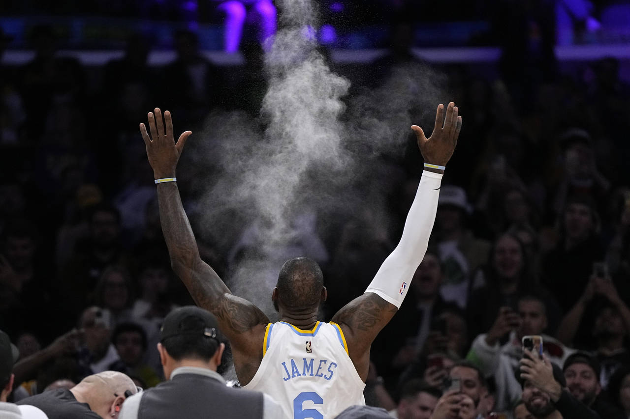 Los Angeles Lakers forward LeBron James tosses powder in the air prior to an NBA basketball game ag...