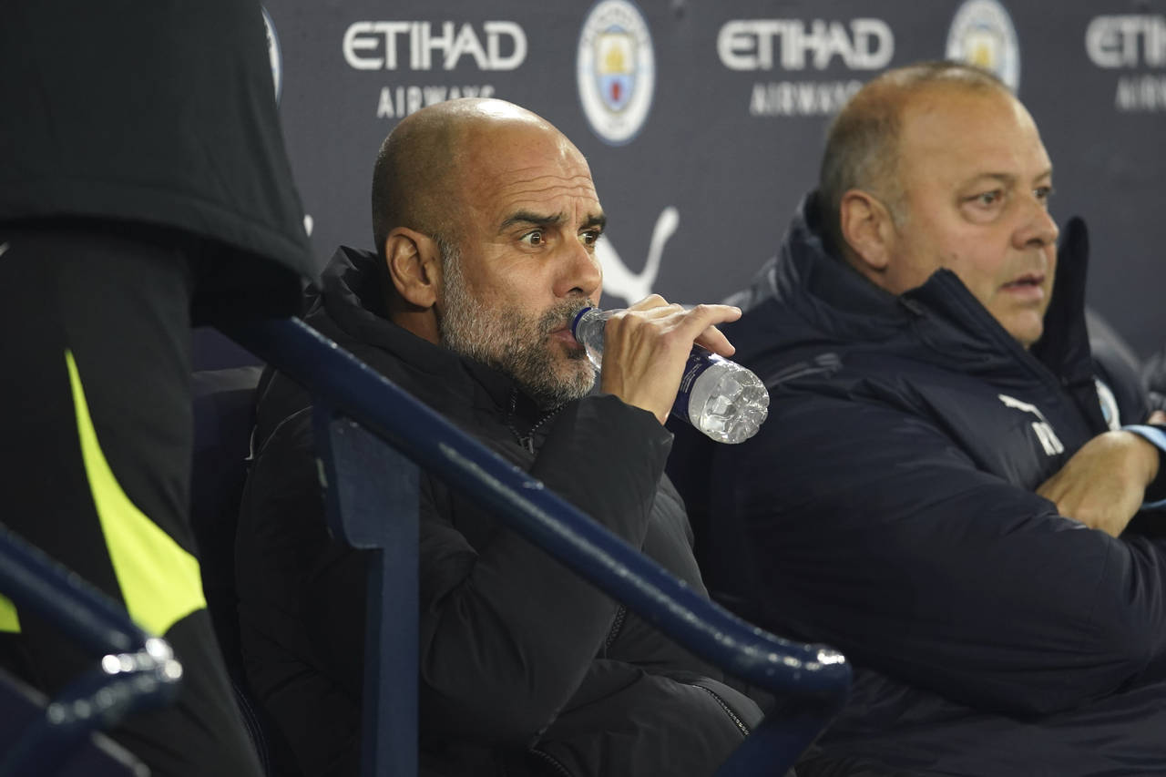 Manchester City's head coach Pep Guardiola sits on the bench before the English FA Cup 4th round so...