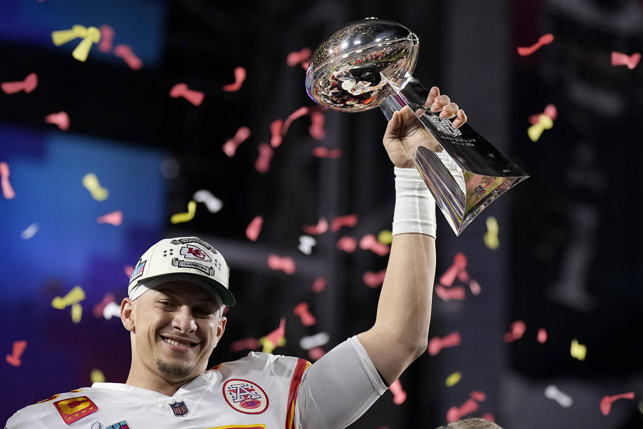 El quarterback Patrick Mahomes (15) de los Chiefs de Kansas City sostiene el trofeo tras vencer a l...
