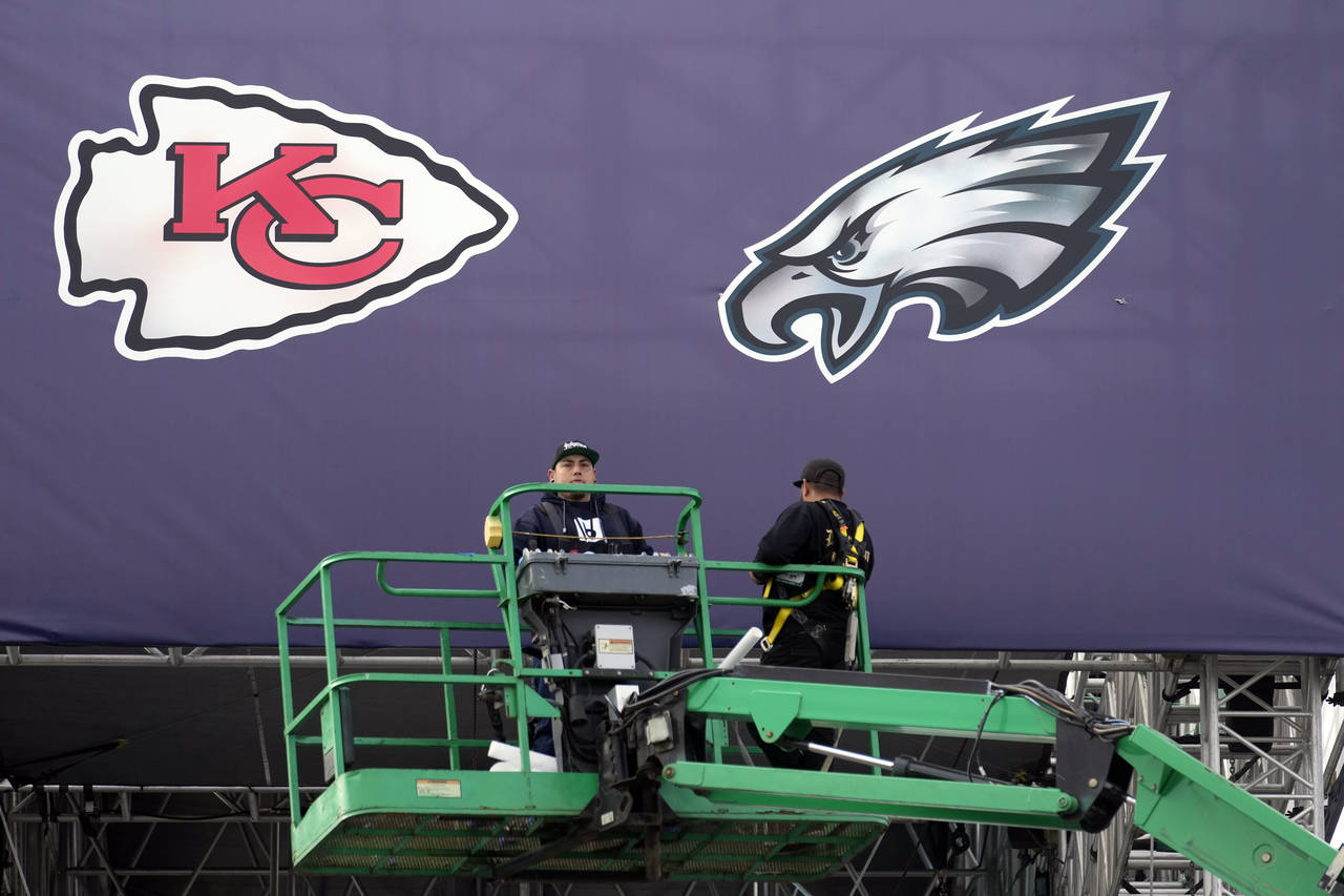 Works place team logos outside State Farm Stadium ahead of Super Bowl 57 NFL football game Saturday...