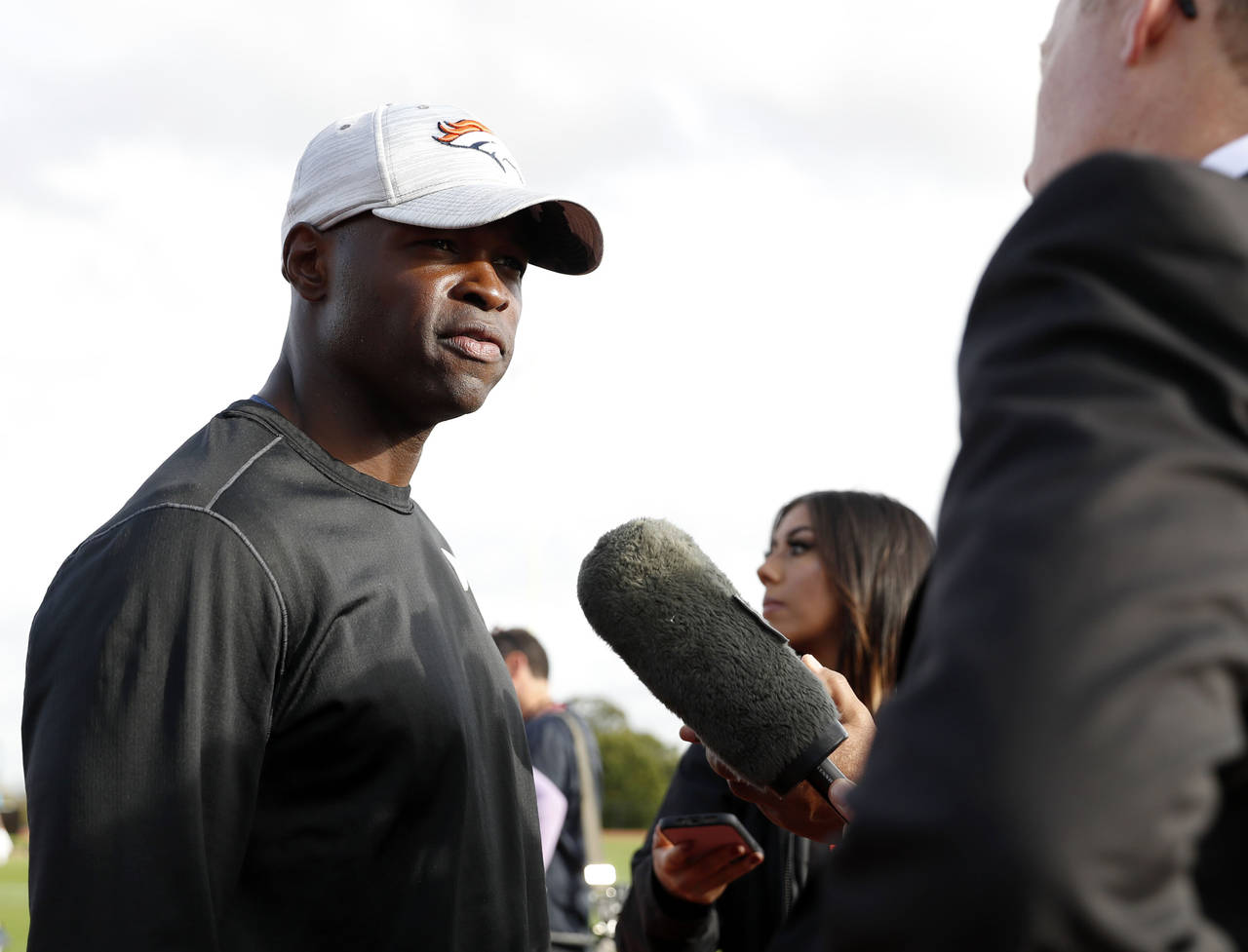 FILE - Denver Broncos defensive coordinator Ejiro Evero, left, speaks with media after a practice s...