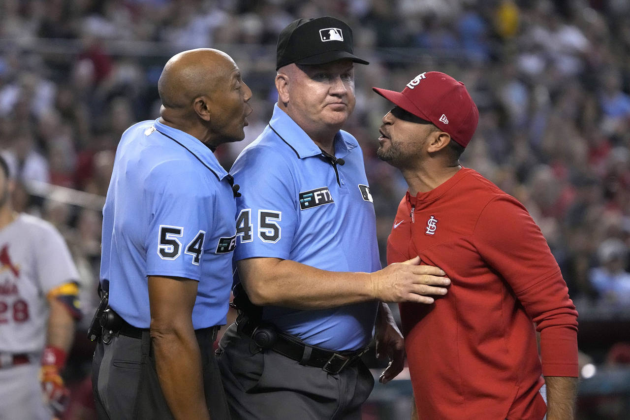 FILE - St. Louis Cardinals manager Oliver Marmol, right, is restrained by umpire Jeff Nelson (45) w...