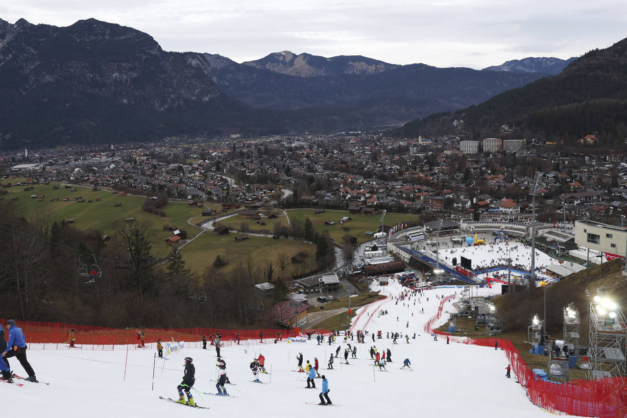 FILE - Athletes inspect the small strip of snow where they will compete in an alpine ski, men's Wor...