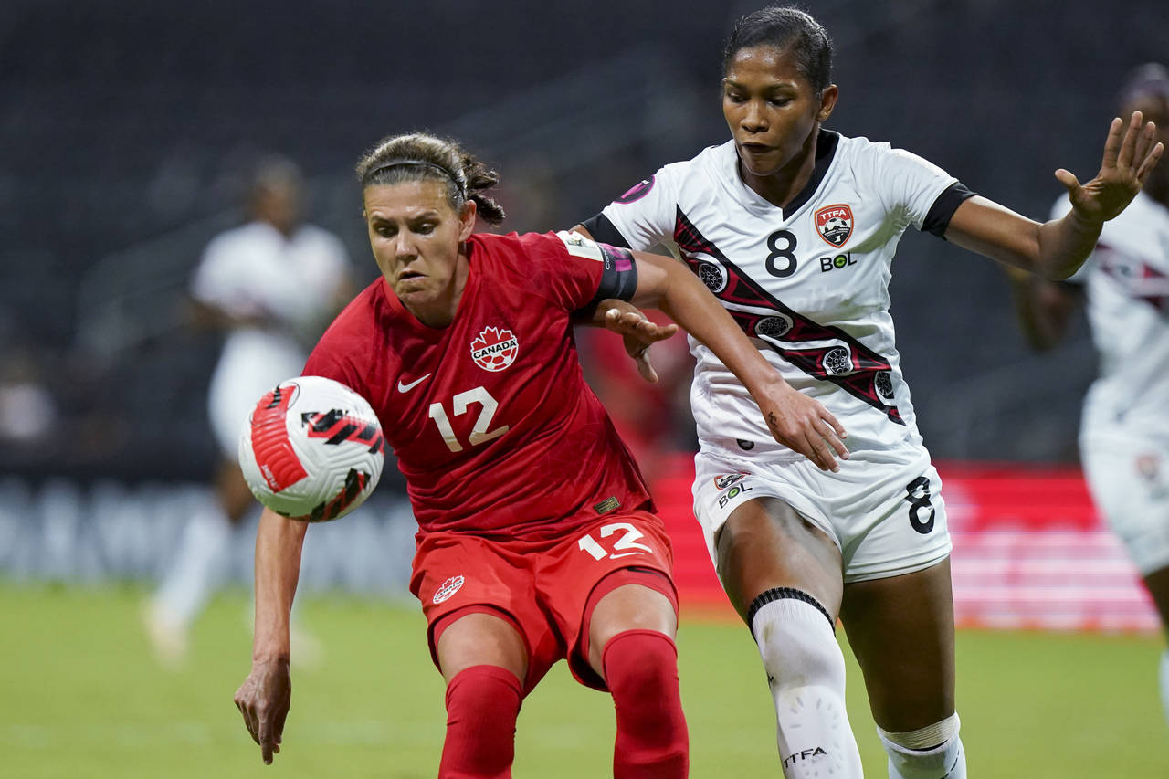 FILE - Canada's Christine Sinclair (12) and Trinidad and Tobago's Victoria Swift compete for the ba...