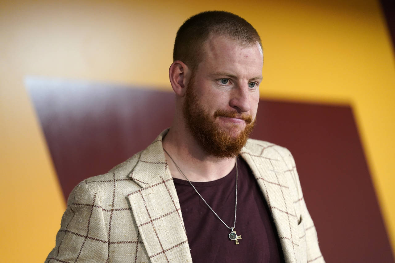 FILE - Washington Commanders quarterback Carson Wentz talks to reporters after a 24-10 loss to the ...
