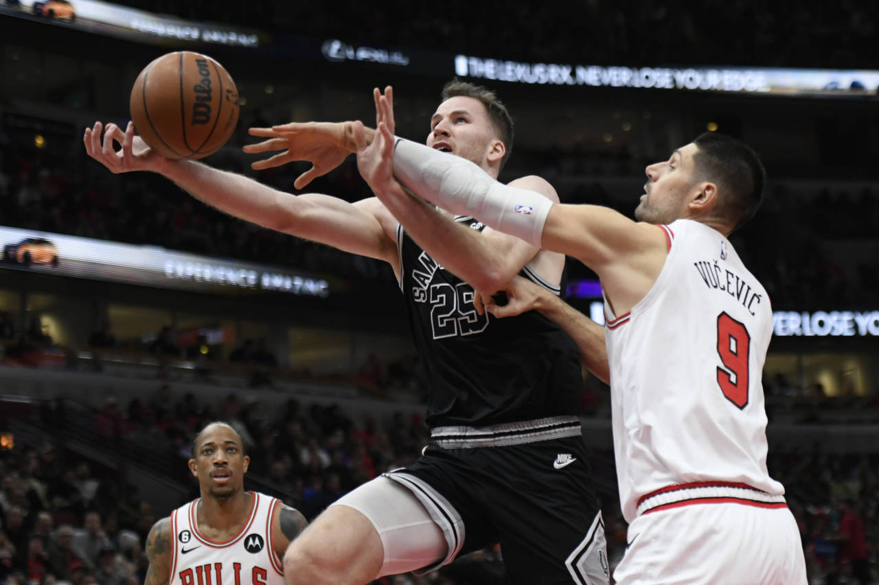San Antonio Spurs' Jakob Poeltl (25) goes up to shoot while being fouled by Chicago Bulls' Nikola V...