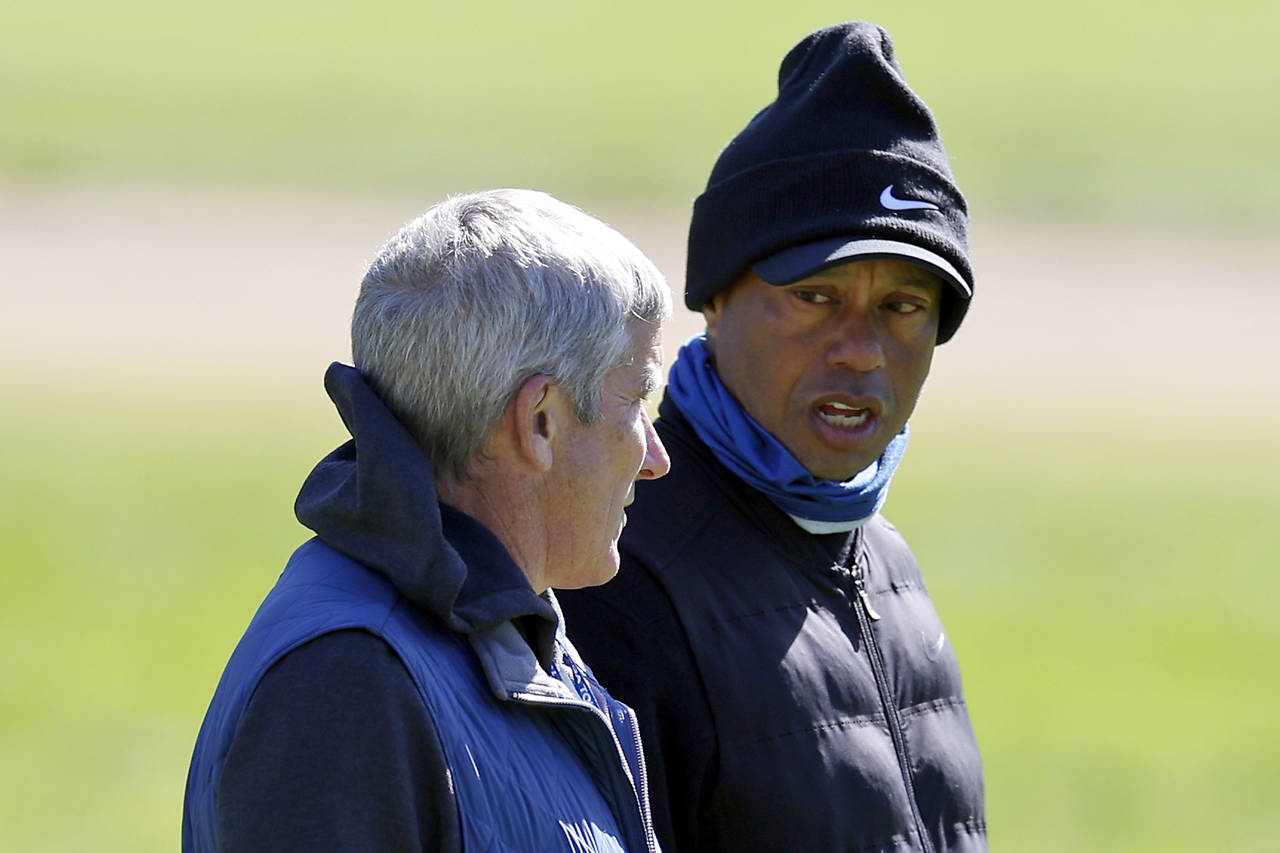 Tiger Woods, right, talks to PGA Commissioner Jay Monahan on the 15th hole during the pro-am of the...