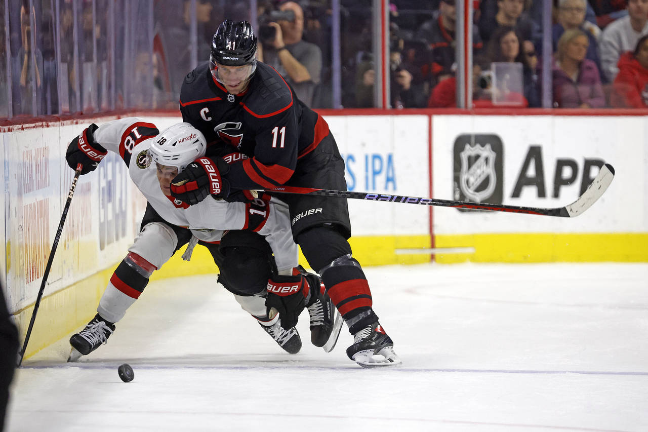 Carolina Hurricanes' Jordan Staal (11) takes Ottawa Senators' Tim Stuetzle (18) off the puck during...