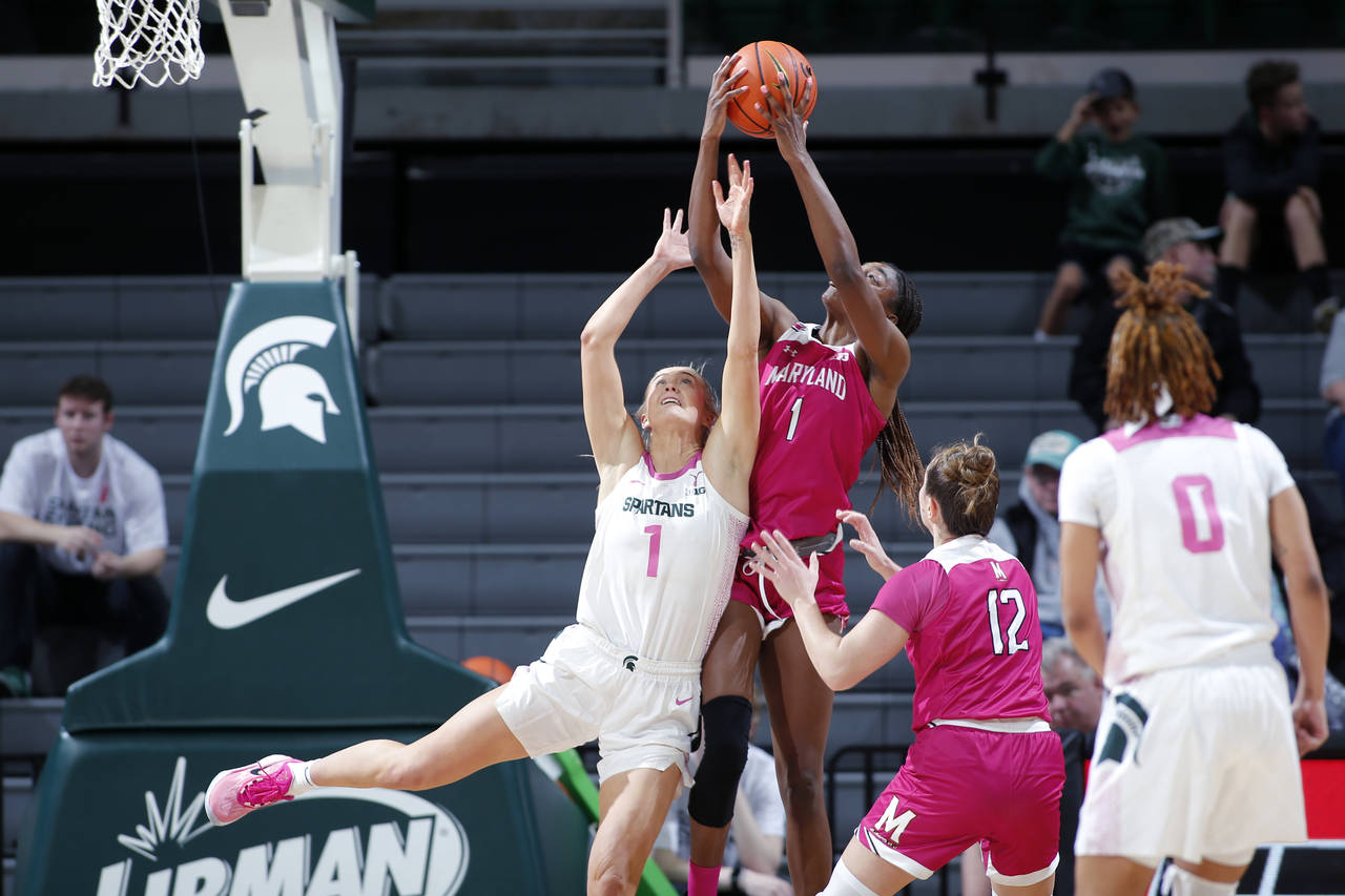 Michigan State's Tory Ozment, left, and Maryland's Diamond Miller reach for a rebound as Maryland's...