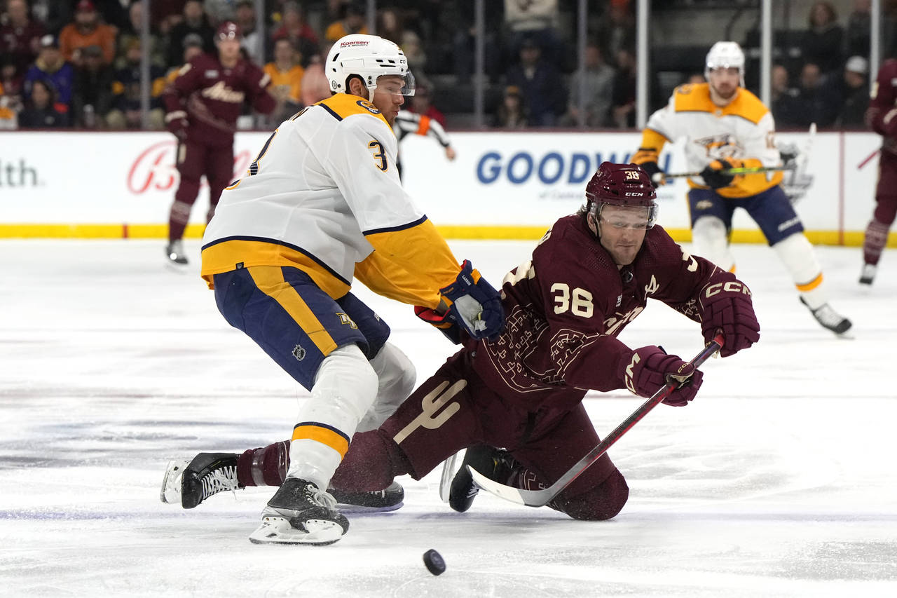 Arizona Coyotes right wing Christian Fischer (36) is checked by Nashville Predators defenseman Jere...