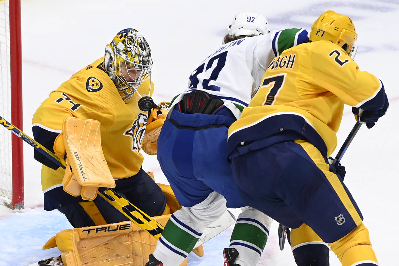 Nashville Predators goaltender Juuse Saros (74) stops a shot by Vancouver Canucks right wing Vasily...