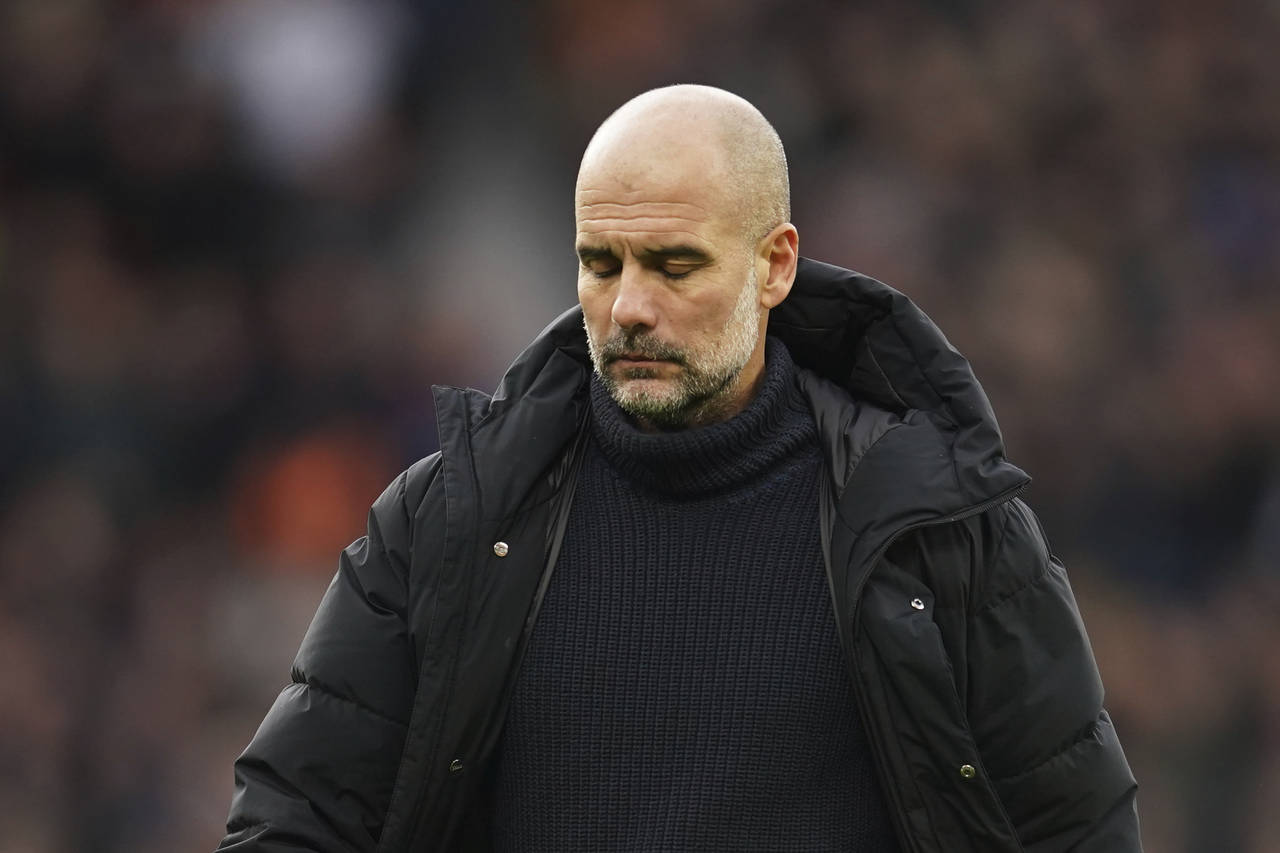 Manchester City's head coach Pep Guardiola walks on the pitch after the English Premier League socc...