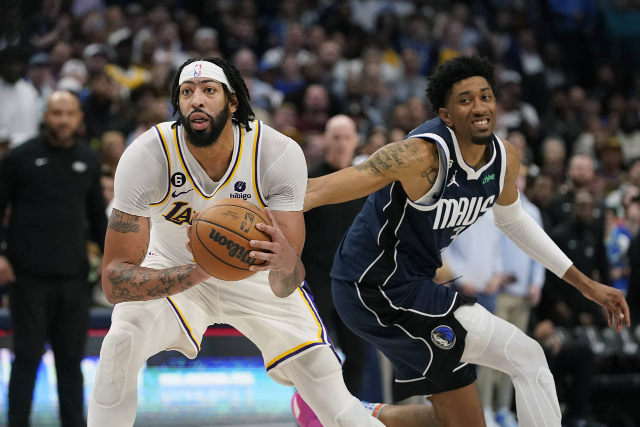 Los Angeles Lakers forward Anthony Davis, left, intercepts a pass meant for Dallas Mavericks forwar...