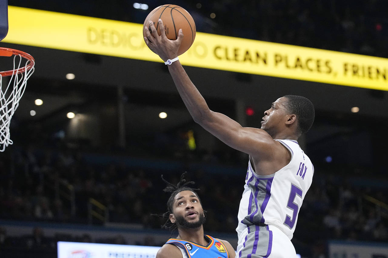 Sacramento Kings guard De'Aaron Fox (5) goes to the basket in front of Oklahoma City Thunder guard ...