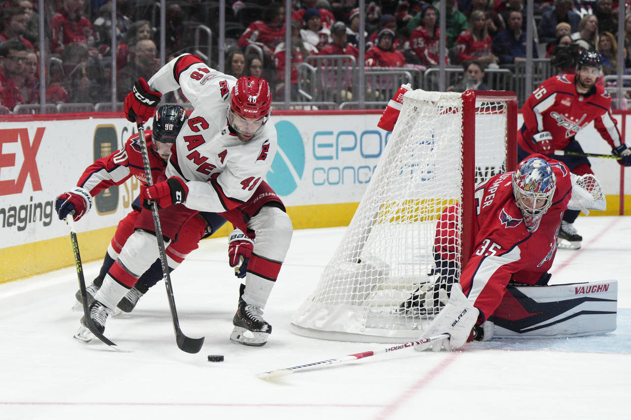 Carolina Hurricanes left wing Jordan Martinook (48) skates with the puck in front of the net as Was...