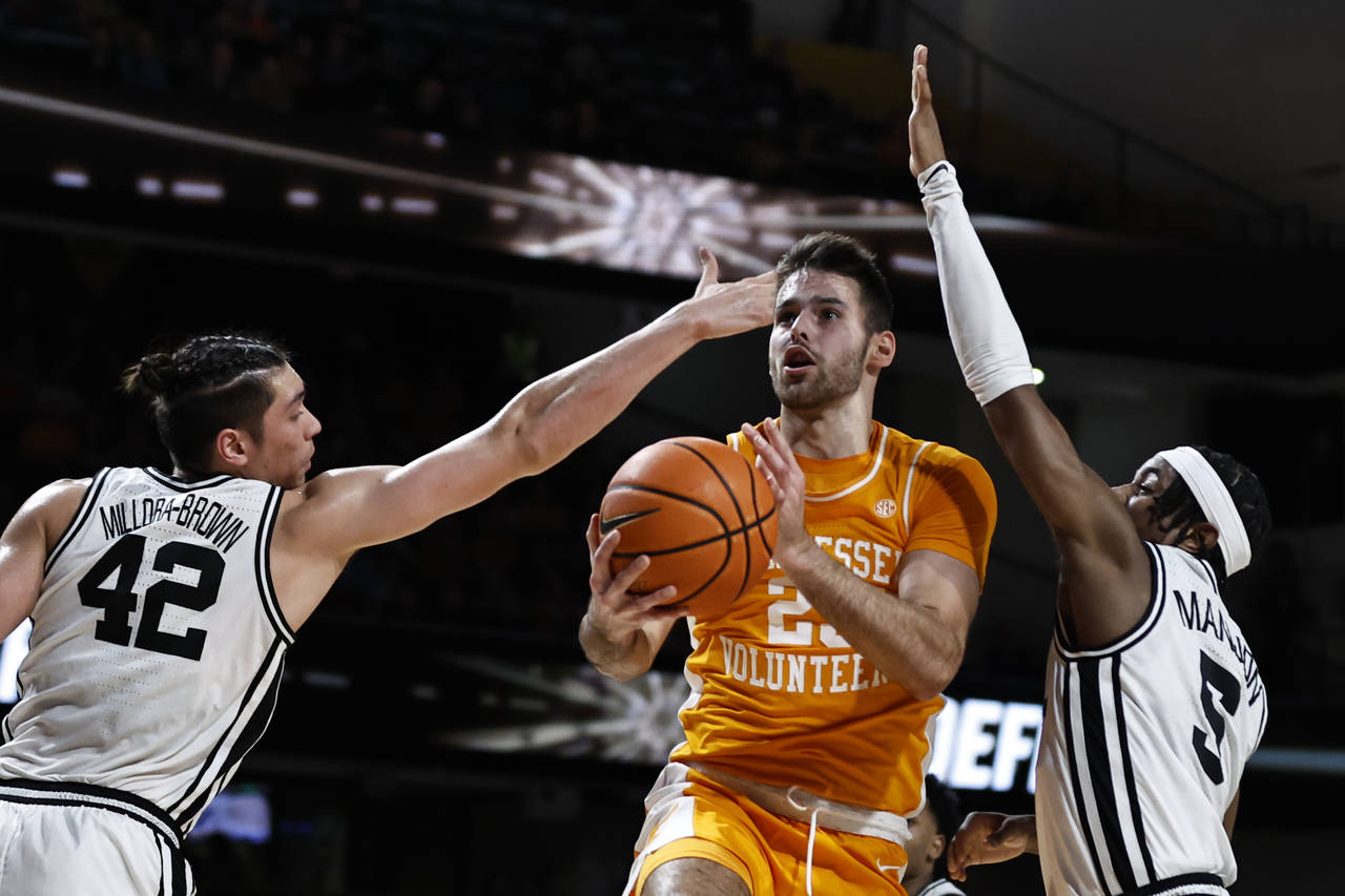 Tennessee guard Santiago Vescovi (25) shoots past Vanderbilt guard Ezra Manjon (5) and forward Quen...