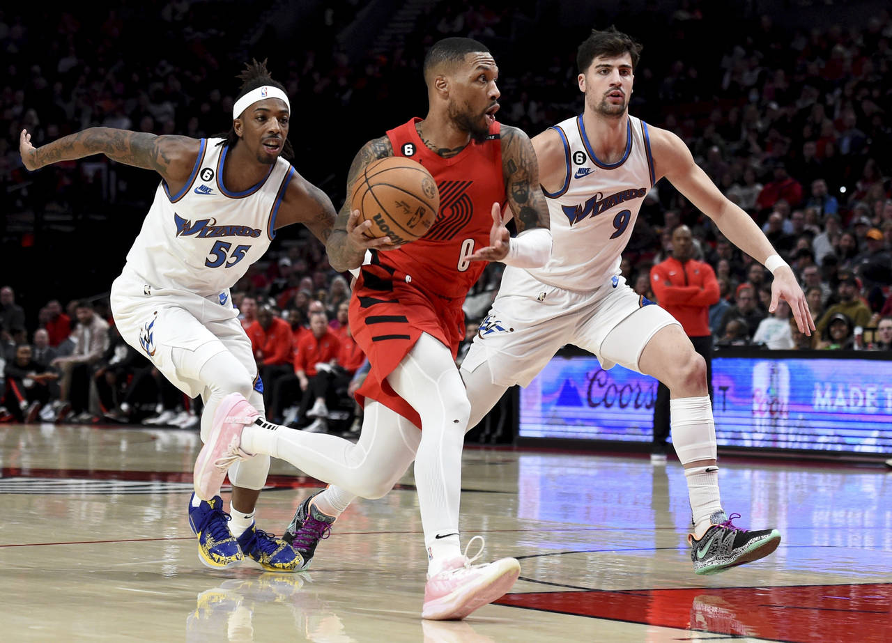 Portland Trail Blazers guard Damian Lillard, center, drives to the basket against Washington Wizard...